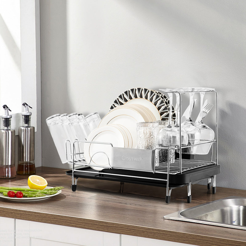 Black expandable dish rack with dishes on a kitchen counter