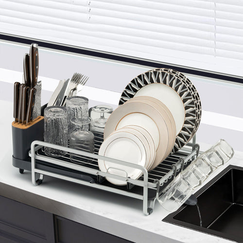 Aluminium dish rack holding dishes beside a sink
